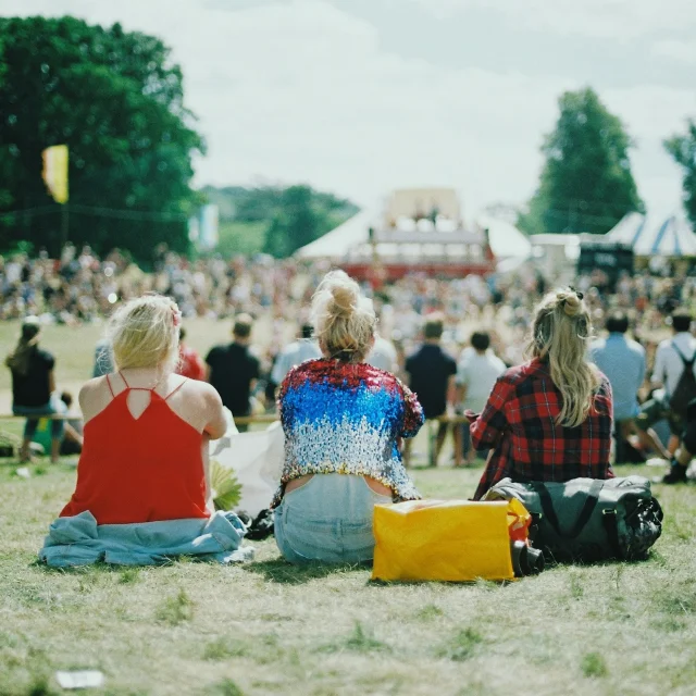 Spectateurs assis sur le sol assistant à une concert