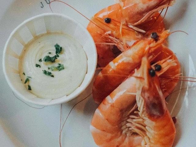 Assiette de crevettes servie avec une sauce au restaurant JUSTE