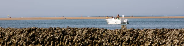 Un bateau naviguant près d'une écluse à poissons sur l'île de Ré.