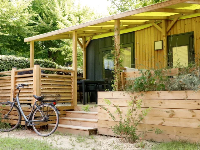 Mobil-home avec terrasse en bois et vélo garé au Camping L'Océan & Spa