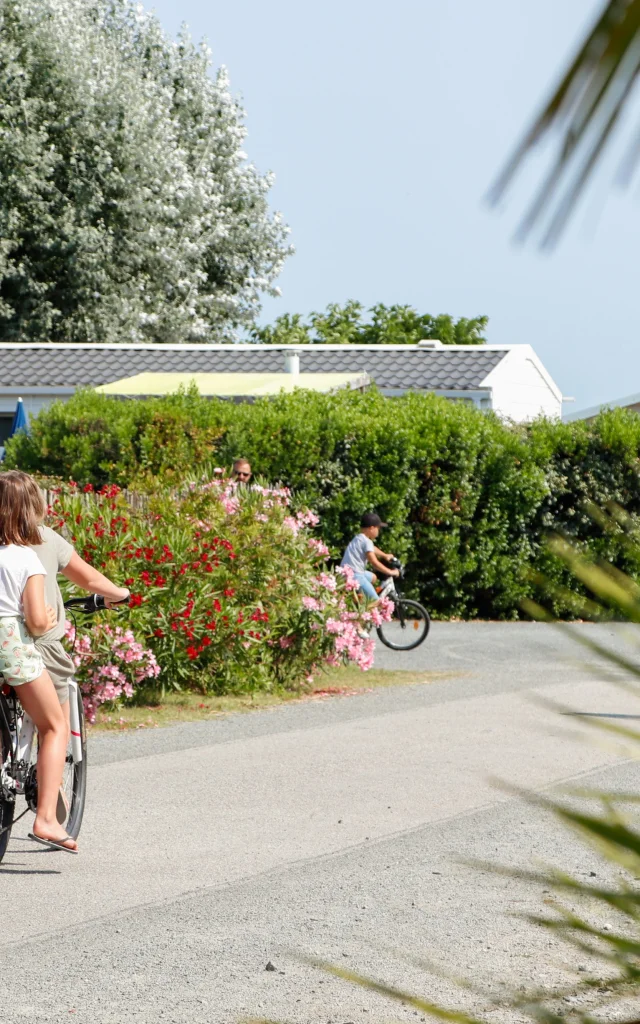 Enfants se promenant à vélo dans les allées du Camping L'Océan & Spa