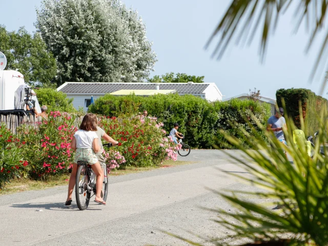 Enfants se promenant à vélo dans les allées du Camping L'Océan & Spa