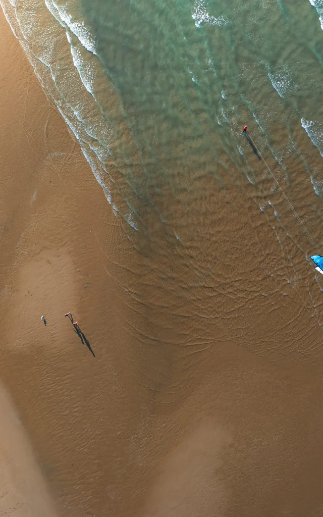 Vue aérienne d'une plage avec un kite surfer.