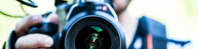 Photographe tenant une caméra de près