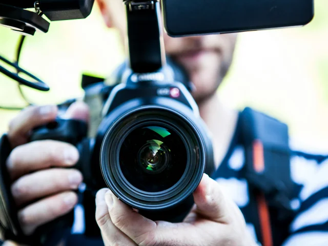 Photographe tenant une caméra de près