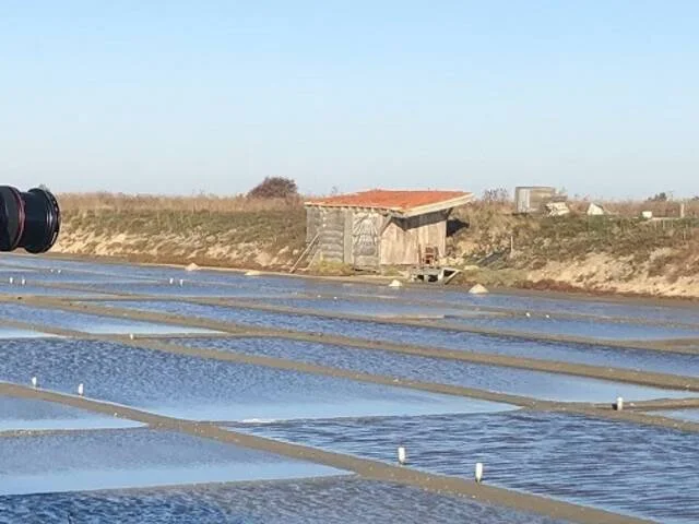 Un photographe en action, prenant des photos des marais salants avec un appareil professionnel.