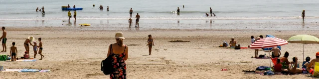 Des vacanciers sur la plage Sud de Rivedoux, avec des bateaux à l'horizon.