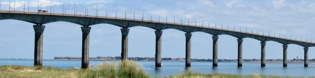 Vue sur le pont de l'île de Ré, s'étendant au-dessus de l'eau sous un ciel bleu.