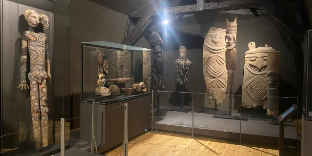 Vue de l'exposition au Muséum d'histoire naturelle de La Rochelle avec des statues anciennes.