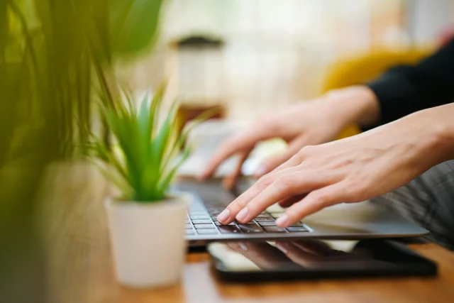 Assistance technique : personne tapant sur le clavier d'un ordinateur portable