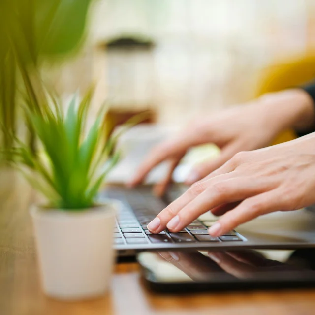 Assistance technique : personne tapant sur le clavier d'un ordinateur portable