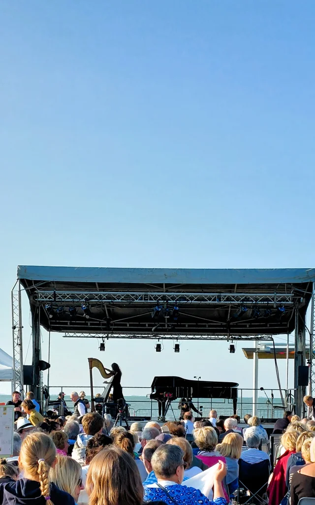 Concert en plein air à Rivedoux avec une foule rassemblée devant une scène.